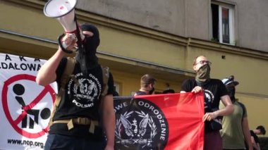 Wroclaw, Polonya - 3 Ekim 2020. Maskeli bir adam bağırarak konuşur. Nazi mitinginde eşitliğe karşı LGBT sembolleri kullanıldı. Polonya 'nın Yeniden Doğuşu afişlerinde Polonya harfleri var.