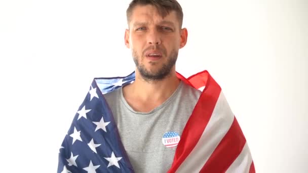 Un joven con una capa, voto en su pecho y con una bandera llama a venir a las urnas. Elecciones estadounidenses. Elecciones presidenciales en los Estados Unidos 2020 — Vídeo de stock