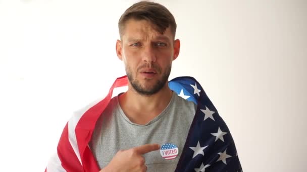 Omröstning 2020 USA: s president. En ung man med ett I-röstmärke håller en amerikansk flagga på sina axlar. Patriotism och val i USA, social aktivism — Stockvideo