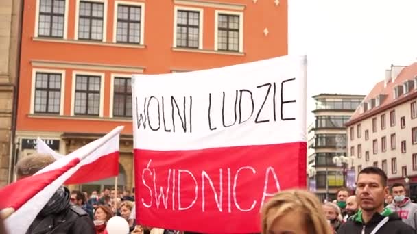 Вроцлав, Польща - 10 жовтня 2020 - Великий протест проти підробленої пандемії і заблокованої ковини-19. Люди без маски протестують на головній площі міста. Напис на поляків. — стокове відео