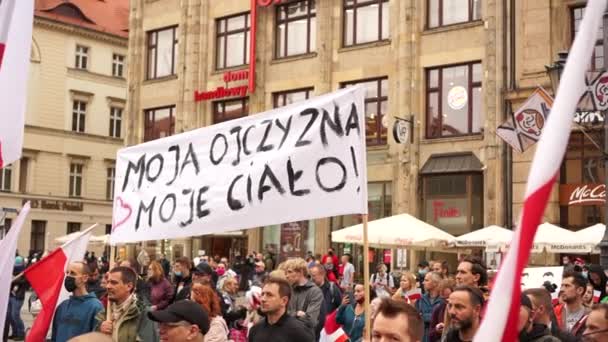 브 로프루, 폴란드 - 2020 년 10 월 10 일 - 가짜 유행병에 항의하는 대규모 항의 행진. 도시의 주요 광장에서는 마스크를 쓰지 않은 사람들이 시위를 벌인다. 폴란드에서 징집 된 나의 나라 - 내 몸 — 비디오