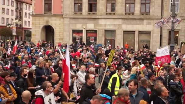 Breslau, Polen - 10. Oktober 2020 - Großer Protestmarsch gegen eine vorgetäuschte Pandemie. Menschen ohne Masken protestieren auf dem Hauptplatz der Stadt. Inschrift auf Polnisch - mein Land mein Körper — Stockvideo