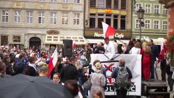 Vratislav, Polsko - 10. října 2020 - Velký mírový protest proti falešné pandemii. Lidé bez masek s polskými vlajkami protestují na hlavním náměstí města — Stock video