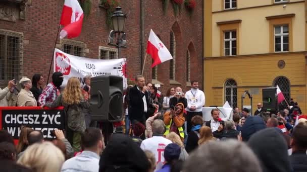 Wroclaw, Polen - 10. Oktober 2020 - Großer friedlicher Protest gegen die gefälschte Pandemie. Die Menschen sprechen vor der Menge mit einem Mikrofon. Inschrift auf Polnisch - vorgetäuschte Pandemie zerstört Polen — Stockvideo