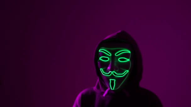 Двоє анонімних людей у страшних масках. Партія Хелловін, фіолетові вогні, лиходії і страх концепції — стокове відео