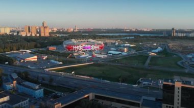 Stadium Discovery Arena'ya doğru uçmanın hiperlapse atışı. Ufukta park manzarası ve nehir ile güzel şehir manzarası timelapse. Yoğun trafiğin olduğu şehir sokakları.