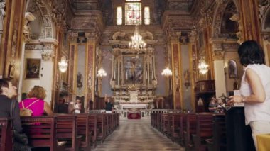 Nice, Fransa - Temmuz 2018: Ünlü Gesu Kilisesi içeriden görünümü. Kamera sunak, banklar ve insanlar oturan ve yavaş çekimde hareket ile güzel zengin dekore iç gösteren.