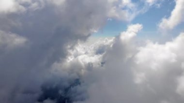 Güzel, kalın, kabarık bulutlar arasında uçuyor. Saf gün ışığında açık mavi gökyüzünde yavaşça hareket eden yumuşak beyaz bulutların şaşırtıcı zamanlaması. Kokpitten doğrudan görüntü.