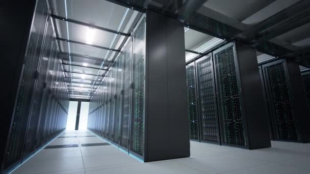 Caméra se déplaçant dans le centre de données dans une lumière tamisée montrant des racks d'équipement serveur partagés par de nombreux passages. Animation de rendu 3D photoréaliste en boucle transparente .