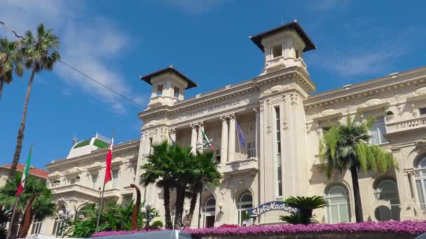意大利圣雷莫 2018年7月 摄像机沿着圣雷莫赌场的外墙轻柔地移动 意大利和欧盟的旗帜在入口处的风中缓缓飘扬 — 图库视频影像