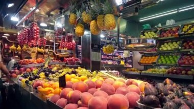 Barselona, Katalonya, İspanya - Temmuz 2018: Ünlü Barselona pazarı Boqueria'da renkli taze meyvelerle tezgahlarda yavaşça hareket eden kamera.