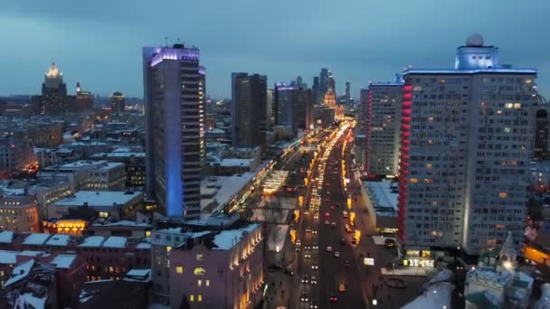 鳥の目のビューから夜のモスクワの明るい光 市内中心部のニューアルバート通りで集中的なトラフィック 広い大通りの側面にネオンライトで照らされた複数階建ての家 — ストック動画