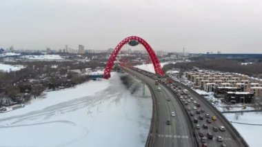 Alacakaranlıkta Moskva nehri üzerinde Pitoresk Köprü üzerinde uçan. Donmuş nehir üzerinde köprüüzerinde yoğun trafik havadan dolly çekim.