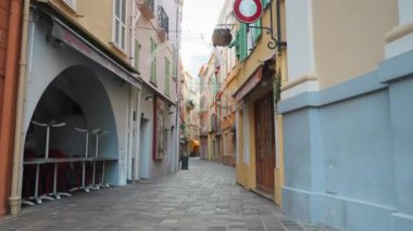 Monte Carlo, Monako - Temmuz 2018: Vitrinler, kafeler, güzel tabelalar ve renkli binalarla Avrupa şehrinin dar ve güzel caddesi boyunca ilerleyen kamera.