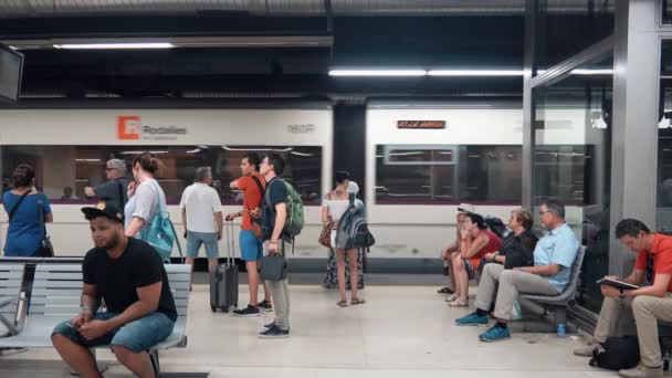 バルセロナ カタルーニャ スペイン 2018 バルセロナの地下生活シーン 人々は座って動き回り 列車を待っている 背景を通り過ぎる地下鉄の列車 — ストック動画