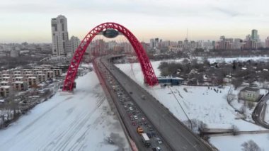 Alacakaranlıkta Moskva nehri üzerinde Pitoresk Köprü üzerinde uçan. Donmuş nehir üzerinde köprüüzerinde yoğun trafik havadan dolly çekim.