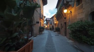 Pürüzsüz kamera sabit slayt eski İspanya köy dar sokak etrafında vurdu, taş duvarlar, çiçeklerle güzel cepheler, sinema dijital kompozisyon veya film klipleri arka plan için mükemmel