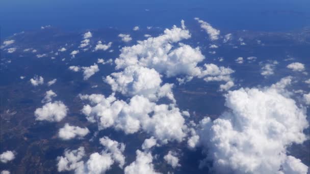 地平線上の遠くに農村風景と深い青い海の美しい景色と白いふわふわの雲の上を飛ぶ 飛行機の窓からの絵のように動く雲景図 — ストック動画