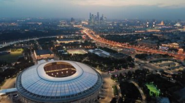 Geç akşam stadyum Luzhniki üzerinde uçan. Gecenin ışıkları Moskova ve en önemli şehir otoyollarından biri. Ufukta Moskova-şehir kuleleri.
