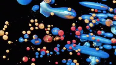 Mavi, turuncu ve kırmızı renklerin yağ mürekkebini siyah arka planda karıştırarak damla ve kabarcıkların güzel desenleri oluşturur. Renkli pırıl pırıl boyalar inanılmaz dokularda yüzeye yayıldı.