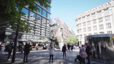 Prag, Çek Cumhuriyeti - Ekim 2018: Franz Kafka anıtının başı. Güneşli bir günde turistik sokaktan ünlü modern sanat heykelinin manzarası. Heykelin yanından geçen ve hareket eden insanlar.