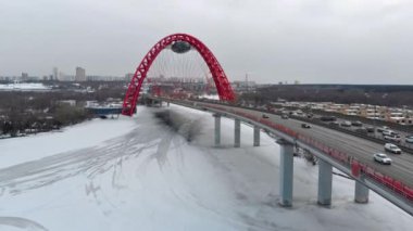 Alacakaranlıkta Moskva nehri üzerinde Pitoresk Köprü üzerinde uçan. Donmuş nehir üzerinde köprüüzerinde yoğun trafik havadan dolly çekim.