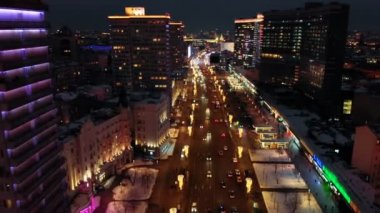 Kuş bakışı moskova'nın parlak ışıkları. Şehrin kalbinde ki Yeni Arbat caddesinde yoğun trafik. Geniş caddenin yanlarında neon ışıklarla aydınlatılan çok katlı evler.