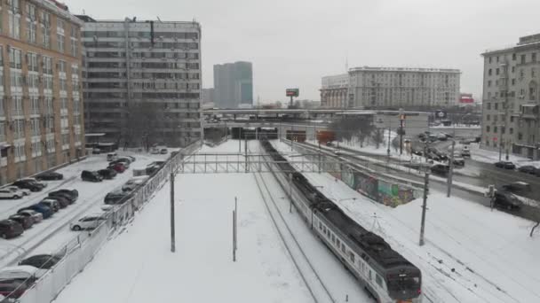 モスクワの曇った日の空中写真鉄道に沿って カメラは古いソ連の建物の間のロシアの郊外の列車に続きます — ストック動画