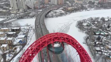 Alacakaranlıkta Moskva nehri üzerinde Pitoresk Köprü üzerinde uçan. Donmuş nehir üzerinde köprüüzerinde yoğun trafik havadan dolly çekim.