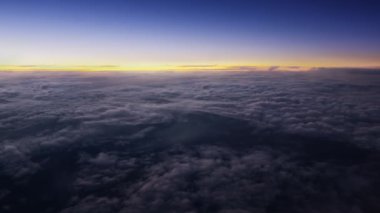 Geç güneşle birlikte akşam bulutlarının üzerinde uçuyor. Güzel güneş ışınları ile hareketli bulutların arasından uçuş. Uçak penceresinden hava yoluyla seyahat etmek. Sinema, arka plan için mükemmel