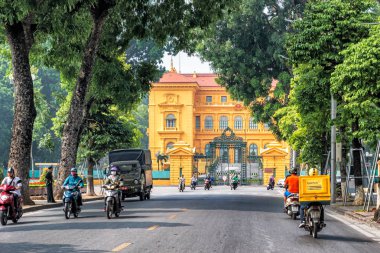 Hanoi, Vietnam - 27 Ekim 2017: Hanoi Cumhurbaşkanlığı Sarayı Vietnam için girişinin önünde sokakta motosiklet sürme insanlar.