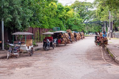 Motosiklet ile ekli arabaları, yerel ürünler Satılık taşıma satırı. Siem Reap, Kamboçya sokak tarafında olduklarını.