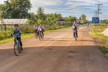 Muang çocuklar biniyor Khong, Laos 10 Kasım 2017 okuldan sonra bisikletler. Muang Khong Laos toprak yol.