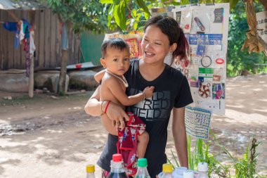 Kampong Cham, Kamboçya - 13 Kasım 2017: Kampong Cham Kamboçya'da yakınlarındaki küçük kasabada yürüyüş onun bebek çocuk ile gülümseyen genç kadın.
