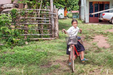 Kralanh, Kamboçya - 20 Kasım 2017: Genç liseli kız Kralanh Kamboçya'da yakınlarındaki küçük bir kasabada evin önünde onun bisikletle.