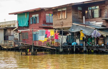 Bangkok, Tayland - 24 Kasım 2017: Kadın loundry Bangkok, Tayland için kanal boyunca ahşap evlerin önünde kuru dışına gidiyor