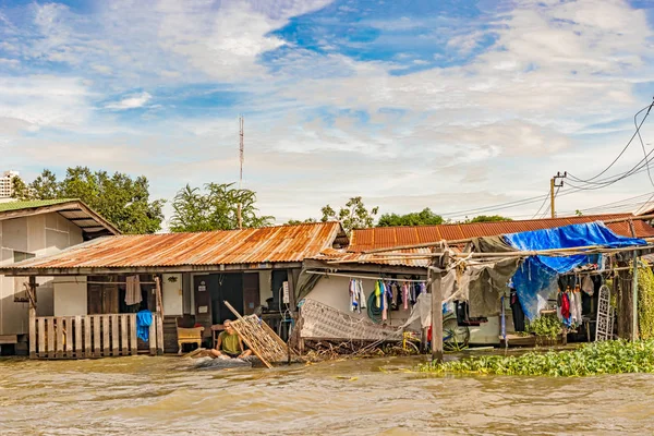 Bangkok, Tayland - 24 Kasım 2017: Adam, Bangkok, Tayland için kanal boyunca sular altında ahşap evin önünde