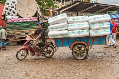 Sihanoukville, Kamboçya 27 Aralık 2017 Sihanoukville olarak da bilinir: Kampong Som, Cambodia Pazar yerinde, ekli sepeti ile onun motosiklet kullanarak mal taşıyan adam.