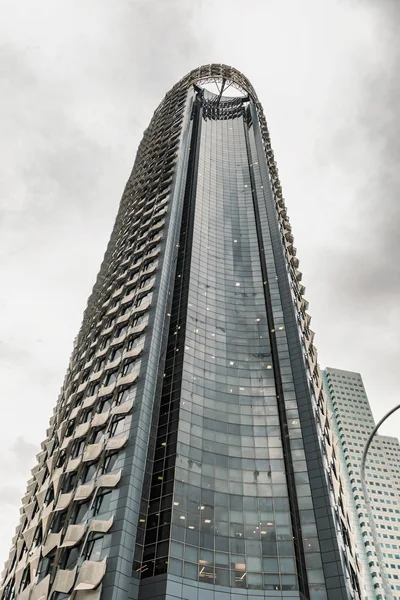 View from the street level at the glass, steel and concrete structures of skyscrapers in downtown Singapore.