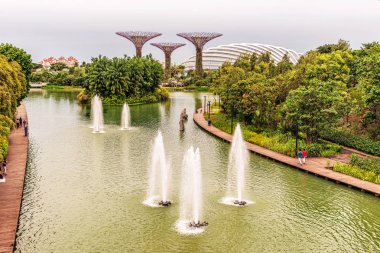 Singapur - 14 Ocak 2018: yusufçuk göl Supertree Grove ve Singapur Bay tarafından bahçelerde çiçek kubbe doğru yürüyen turist.
