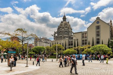 Medellin, Kolombiya - 26 Mart 2018: turist Medellin, Kolombiya Botero Plaza yürümek. Kültür Sarayı Rafael Uribe ve Coltejer bina, semboller şehrin arka plan olduğunu.