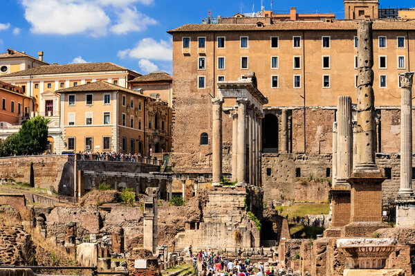 Rome, Italy - August 29, 2014: Tourists visiting Roman Forum passing by Temple of Saturn, Rome, Italy.