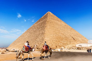 Kahire, Mısır - 31 Aralık 2014: Giza Piramidine ve develere binen turistlere bakın
