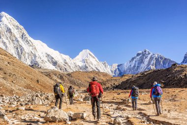 Manzaralı vadiyi, Himalaya dağlarını, Lobuche ve Gorakshep arasındaki Everest Ana Kampındaki yürüyüşçüleri izleyin.