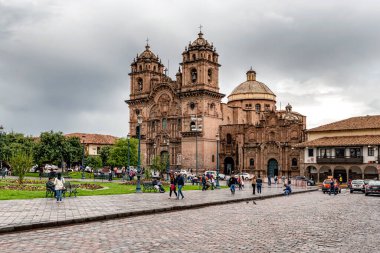 Cusco, Peru - 2 Nisan 2019: Cusco şehrinin merkez noktası olan Peru 'daki Plaza de Armas' da İsa 'nın Katedrali ve Tapınağı' nı ziyaret edenler.