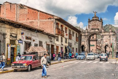Cusco, Peru - 9 Nisan 2019: Cusco, Peru 'da arka planda bir kilise bulunan Plaza de Armas yakınlarındaki eski koloni binalarıyla caddedeki trafiğe bakın.