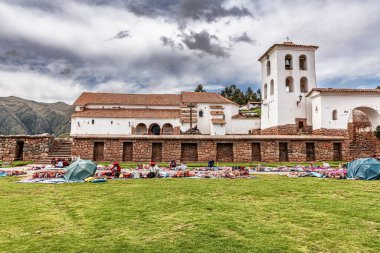 Chinchero, Peru 4 Nisan 2019 Chinchero, Peru 'daki kilisenin önündeki merkez Plaza' da. Geleneksel Peru el işi satan ve Alpaca yününden örgü ören yerli bir kadın.
