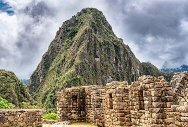 Peru 'daki Machu Picchu şehrinde binalar, evler. Wayna, Huayna Picchu dağ zirvesi arka planda.