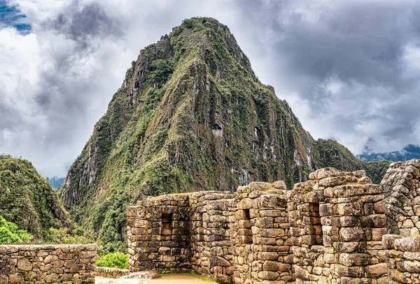 Peru 'daki Machu Picchu şehrinde binalar, evler. Wayna, Huayna Picchu dağ zirvesi arka planda.