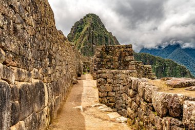 Peru 'daki Machu Picchu şehrindeki binalar ve evler. Wayna, Huayna Picchu dağ zirvesi arka planda.